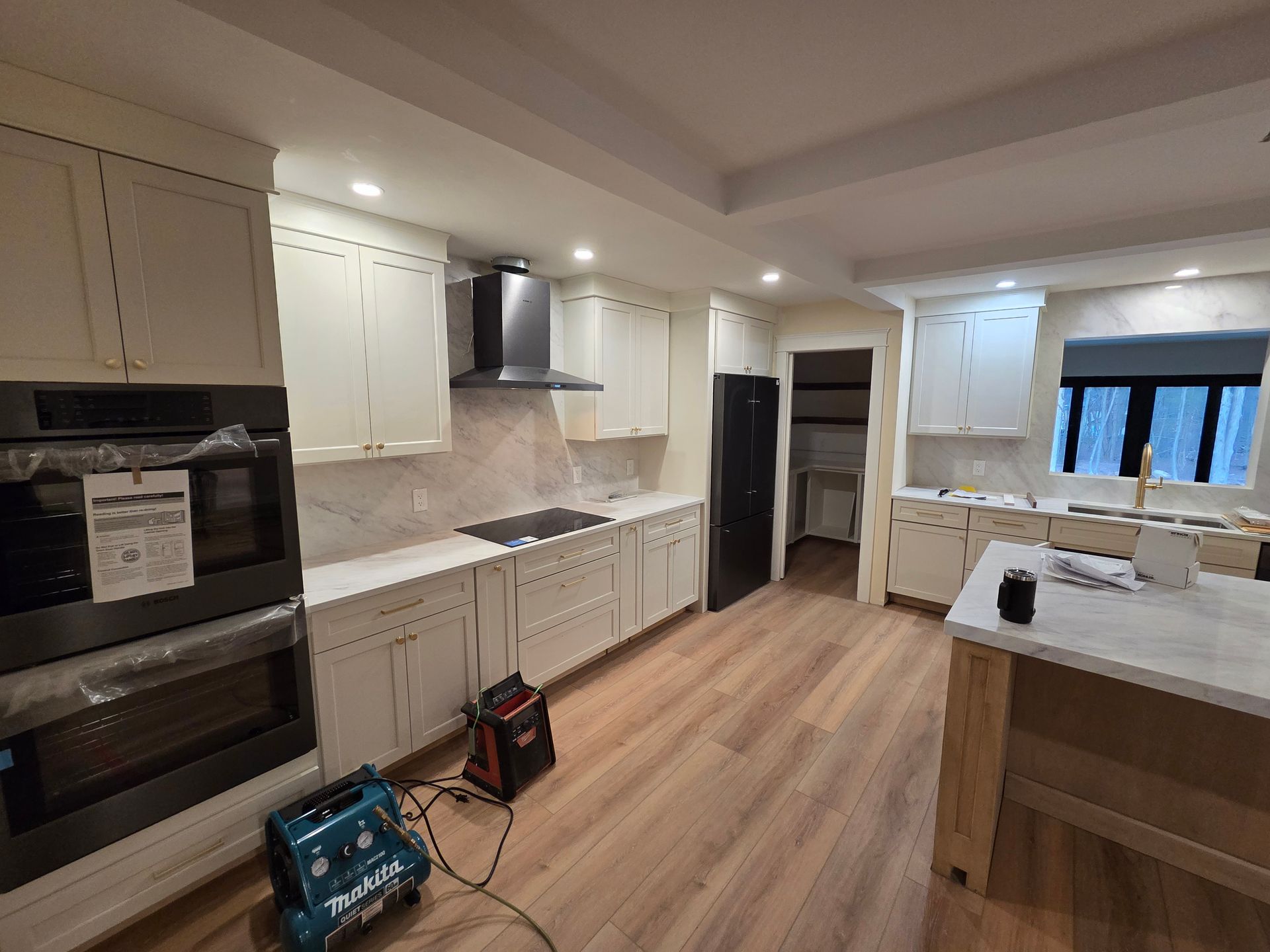 A kitchen with white cabinets and stainless steel appliances is being remodeled.