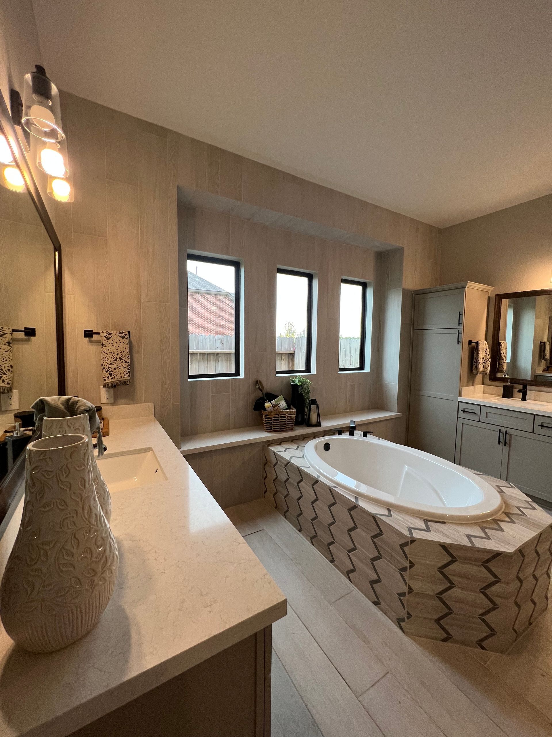 A bathroom with a tub , sink and mirror