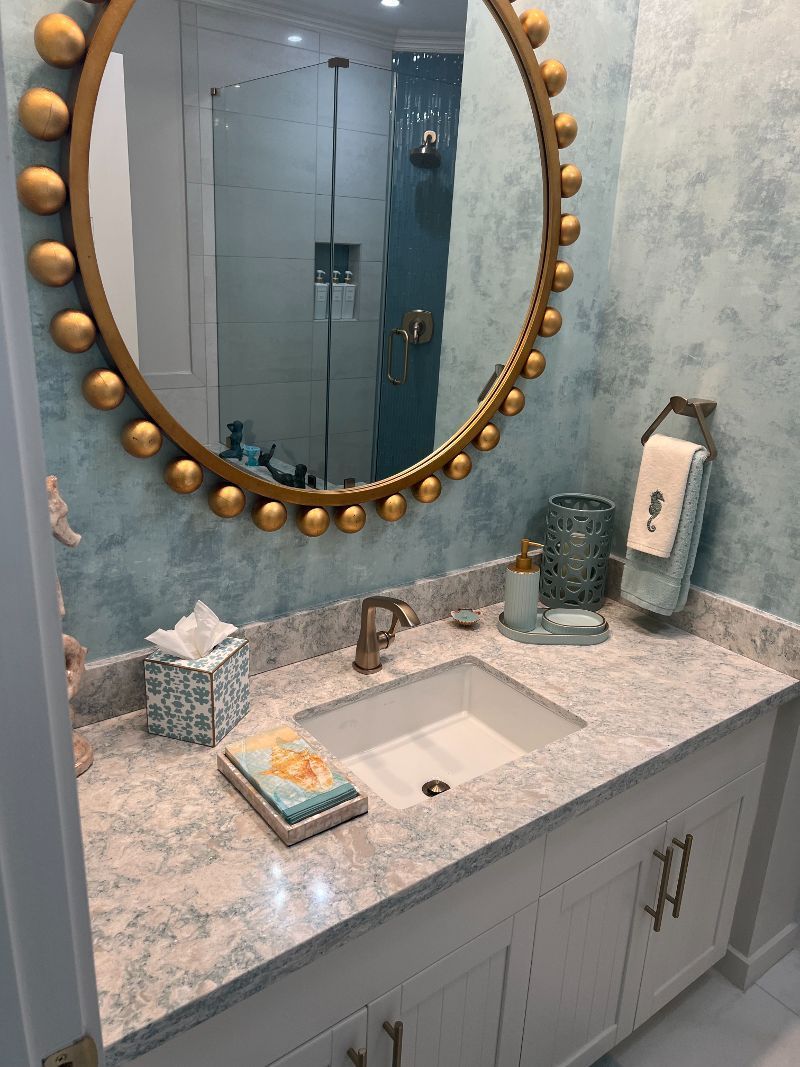 A bathroom with a sink and a round mirror
