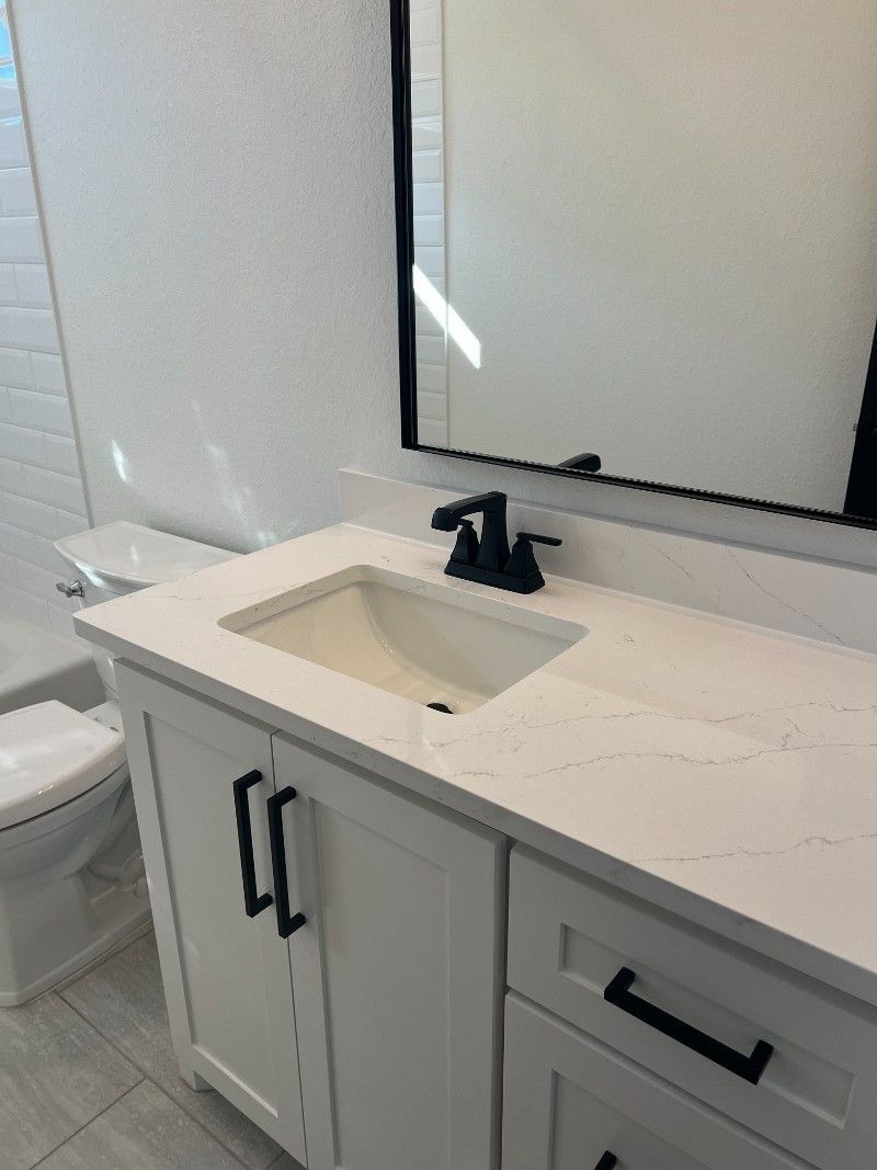 A bathroom with a sink , toilet and mirror