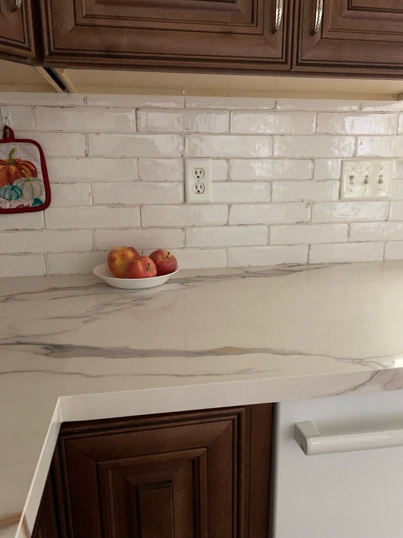A kitchen counter with a bowl of apples on it.
