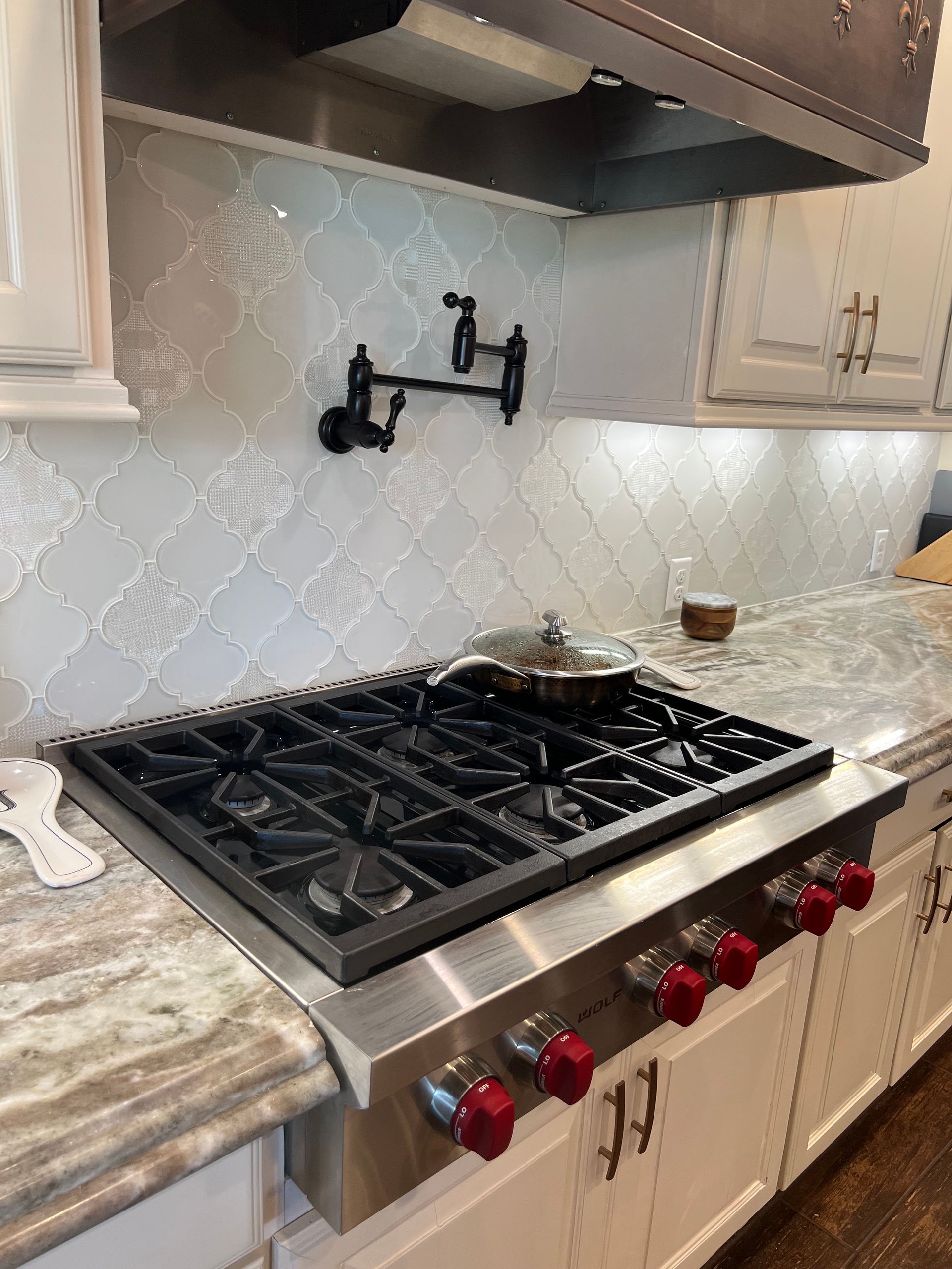 A stove top oven with a pot on top of it in a kitchen.