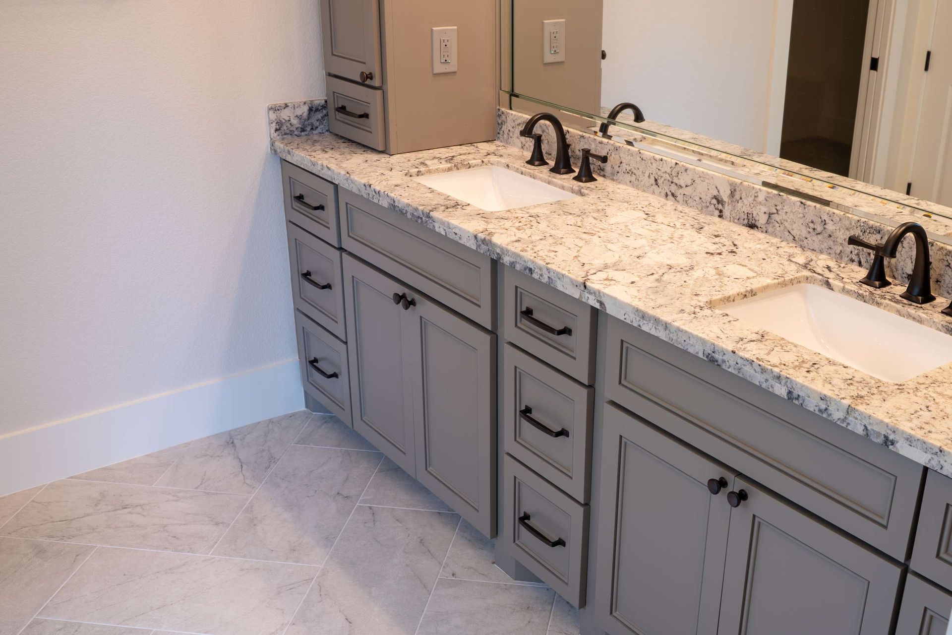 A bathroom with two sinks and a large mirror.