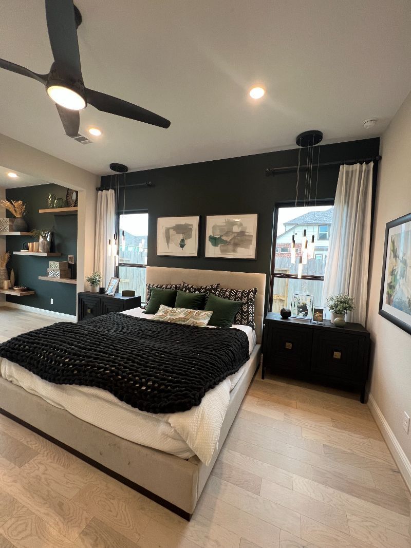A bedroom with a large bed and a ceiling fan.