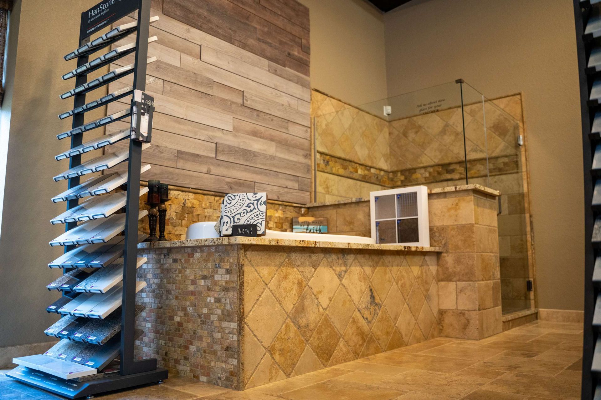 A bathroom with a bathtub and a display of tiles.