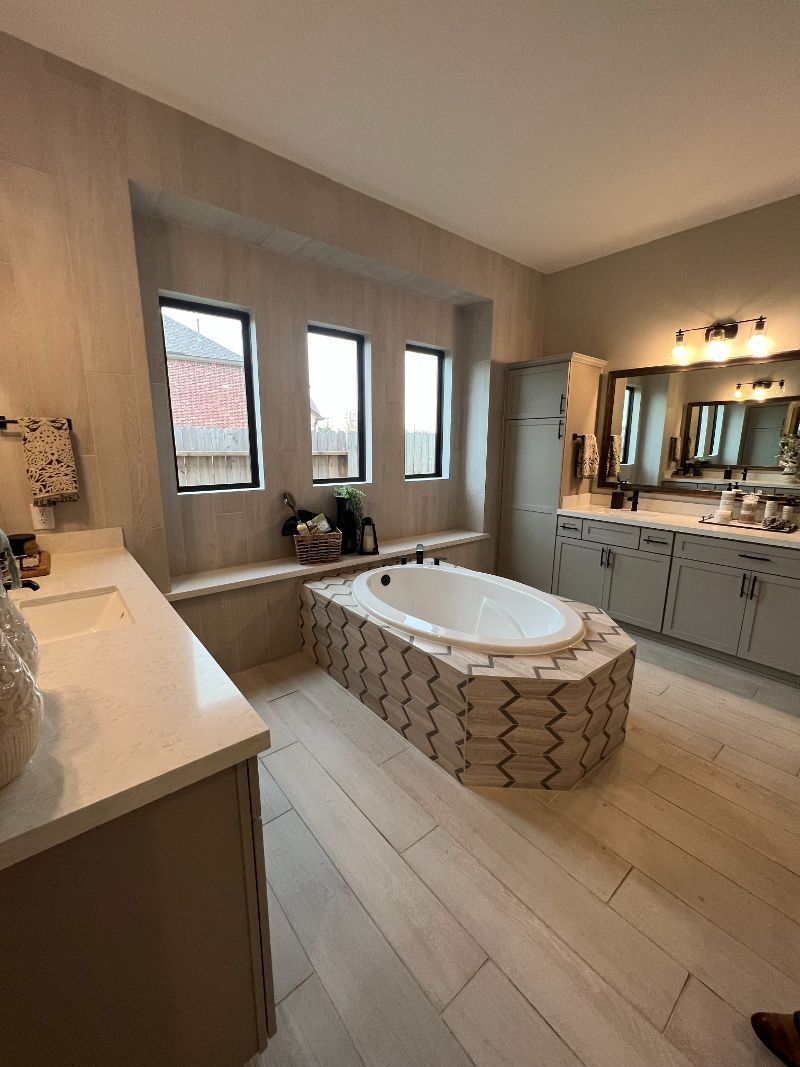 A bathroom with a tub , sinks , and mirrors.