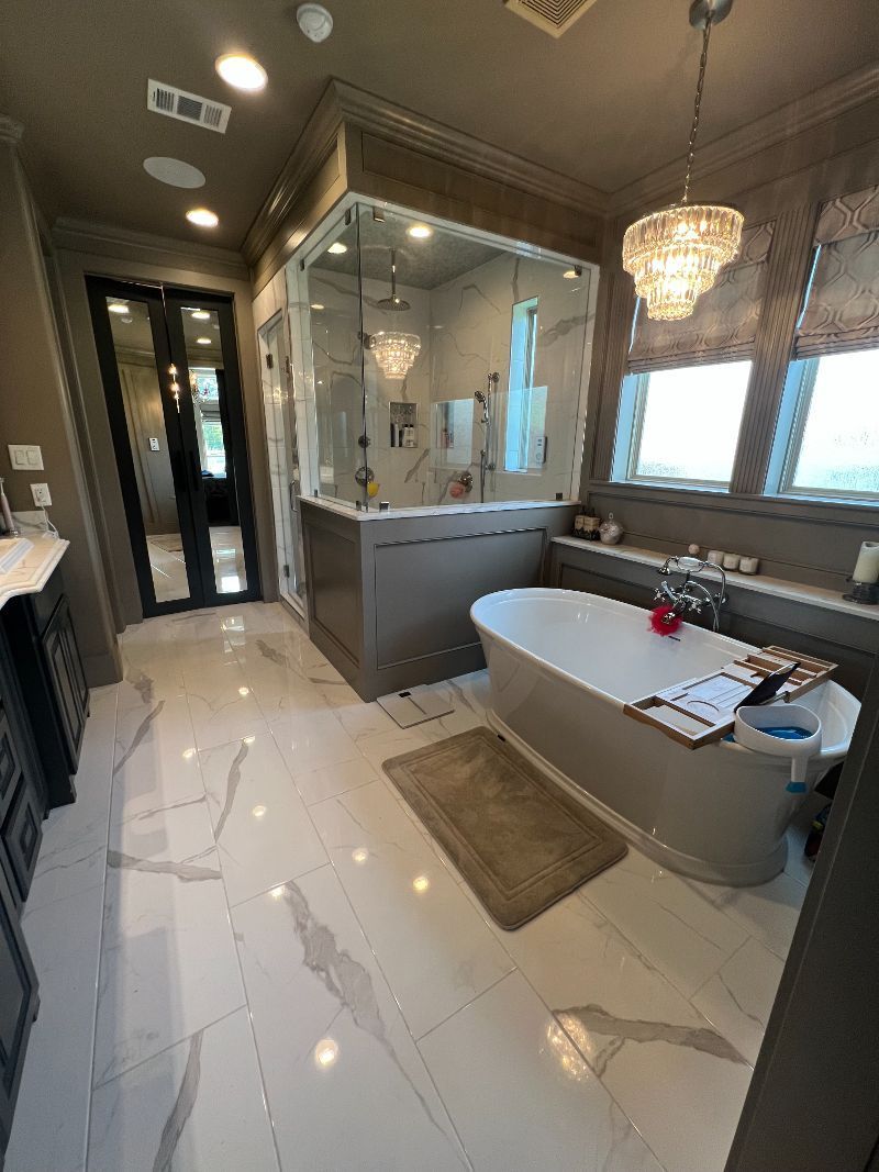 A bathroom with a tub , sink , and shower.