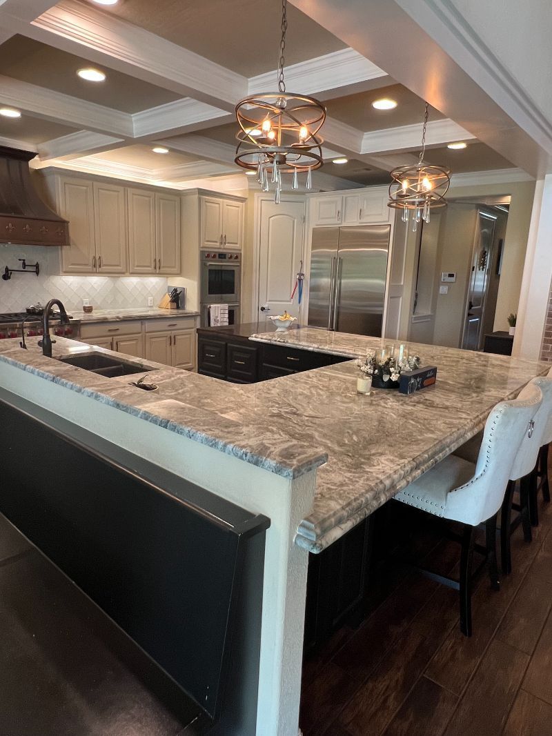 A kitchen with granite counter tops and stainless steel appliances.