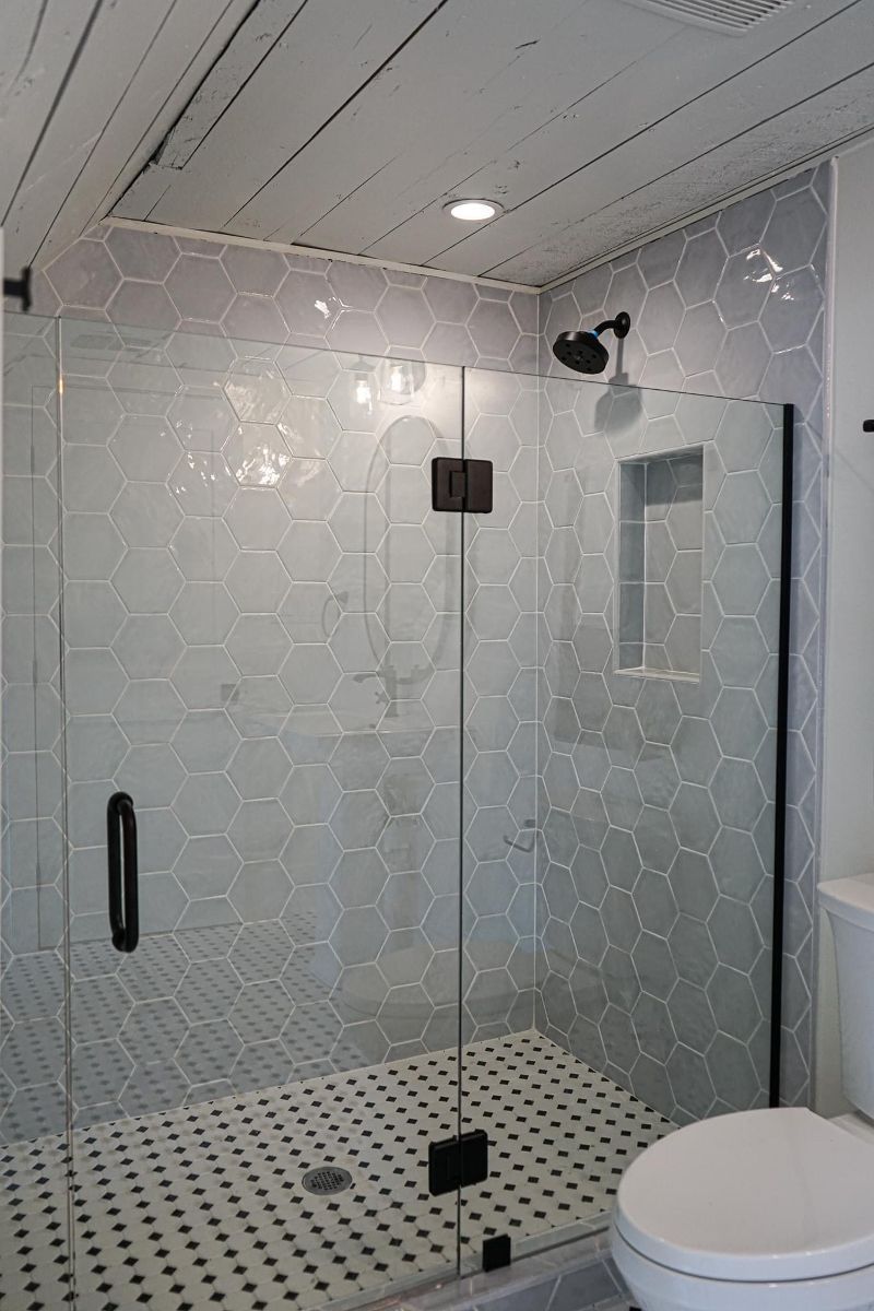 A bathroom with a walk in shower and a toilet.