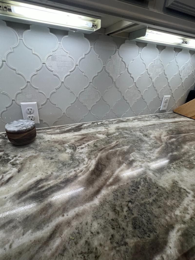 A close up of a kitchen counter with a marble counter top.