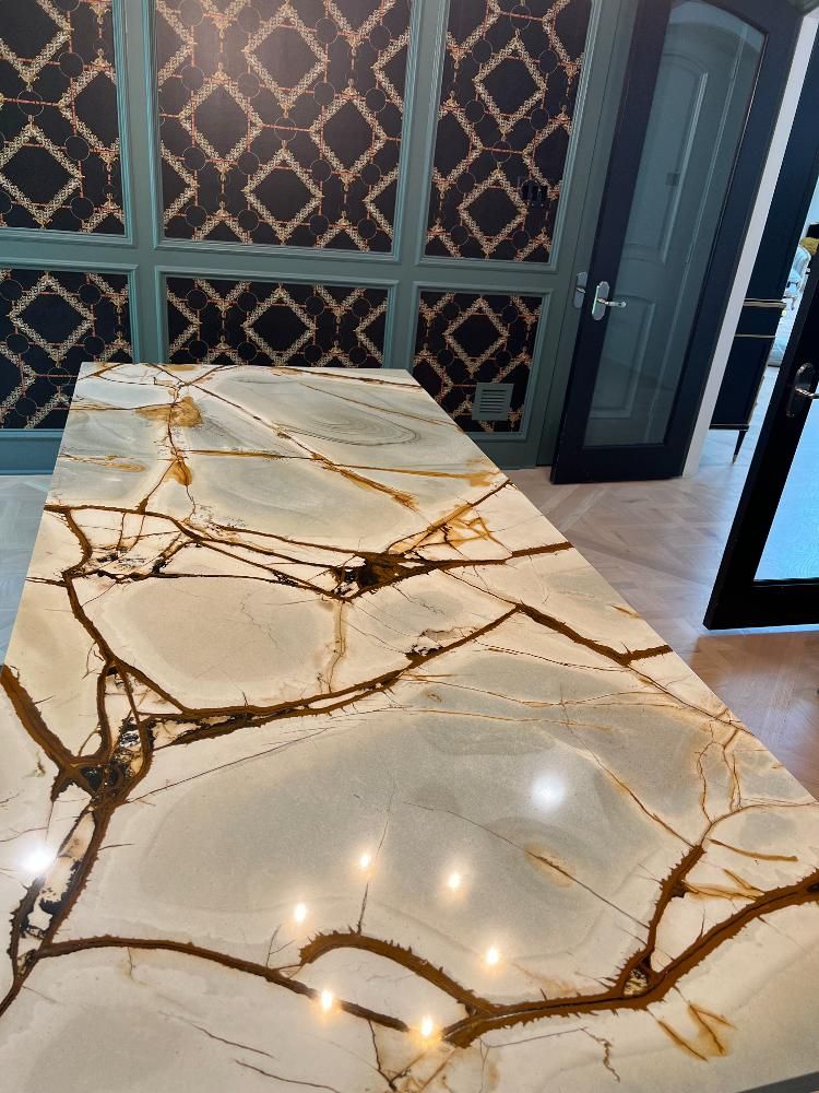 A marble counter top in a kitchen with a patterned wall behind it.