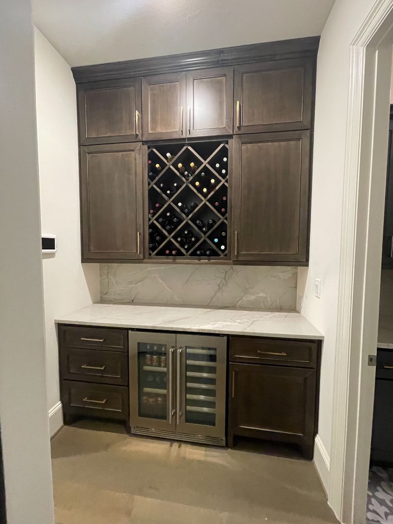 A kitchen with a wine rack and a refrigerator.