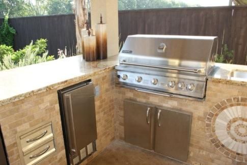 A stainless steel grill is sitting on top of a counter in a kitchen.