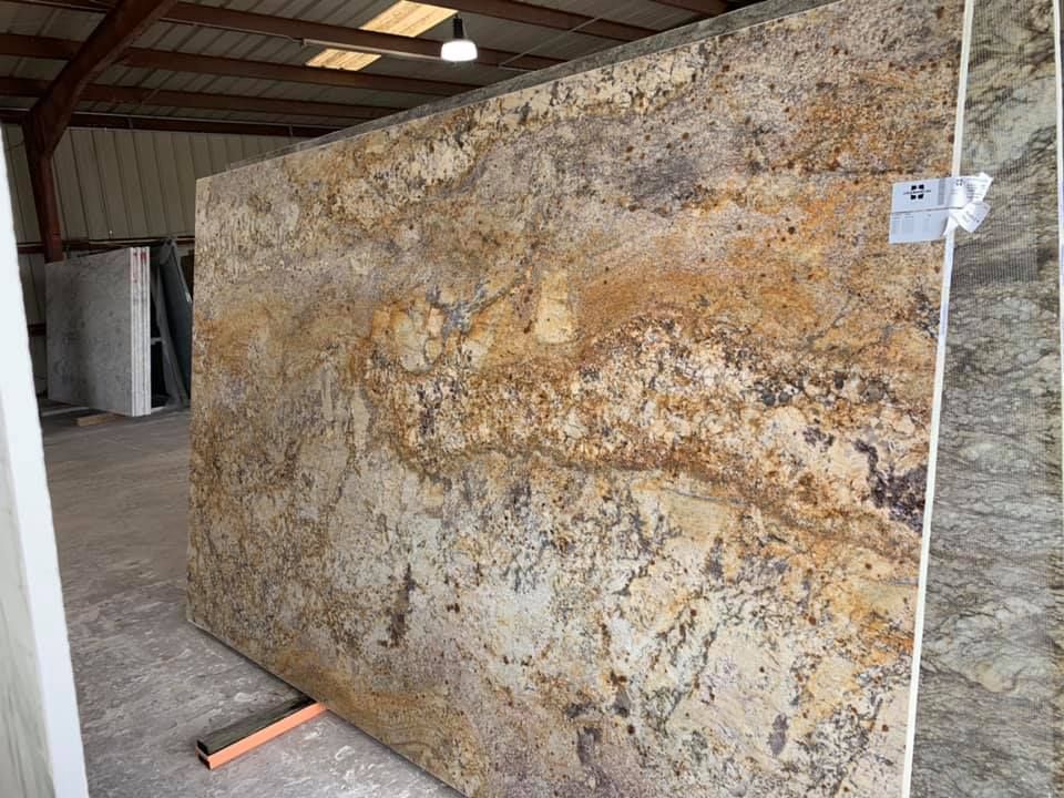 A large slab of granite is sitting on a stand in a warehouse.