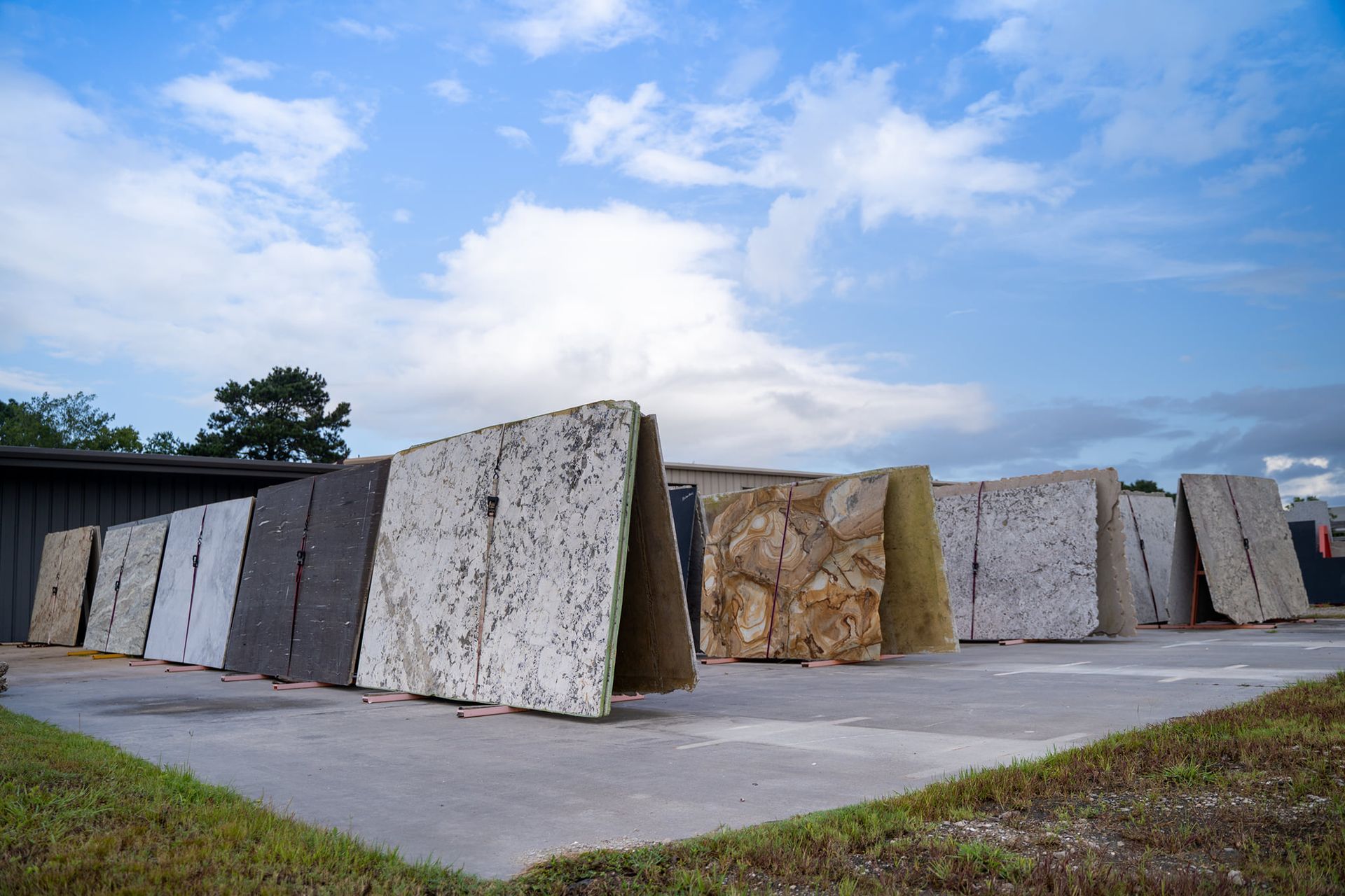 A row of granite slabs are stacked on top of each other in a parking lot.