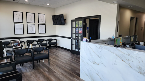 A waiting room with chairs and a counter in a dental office.