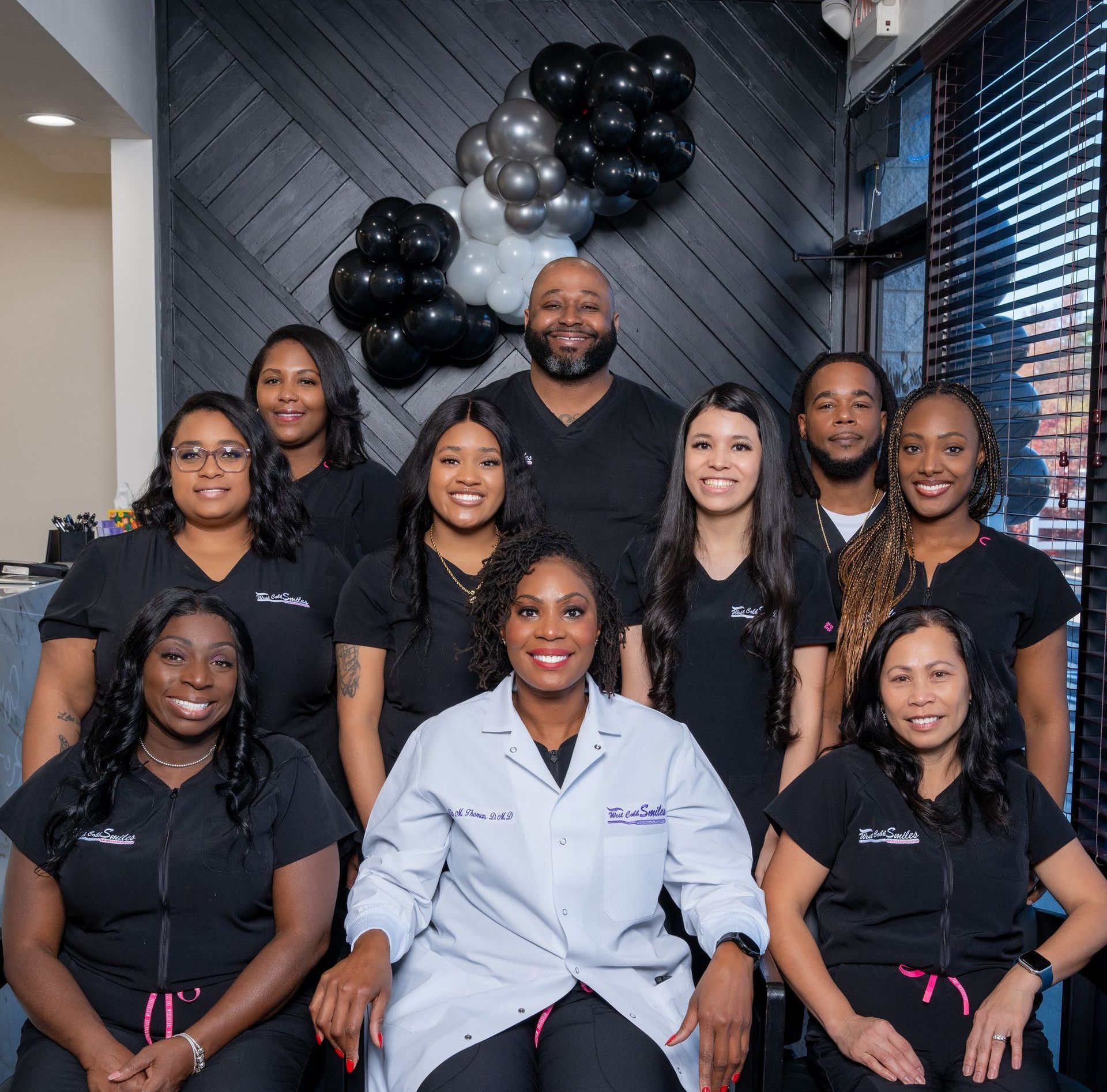 A group of people posing for a picture with balloons in the background