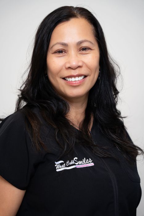 A woman in a black shirt is smiling for the camera.