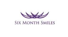 The logo for six month smiles is purple and has a crown on it.