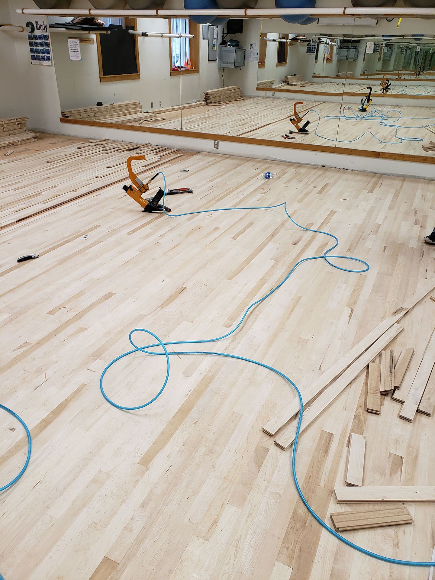 A wooden floor is being installed in a dance studio