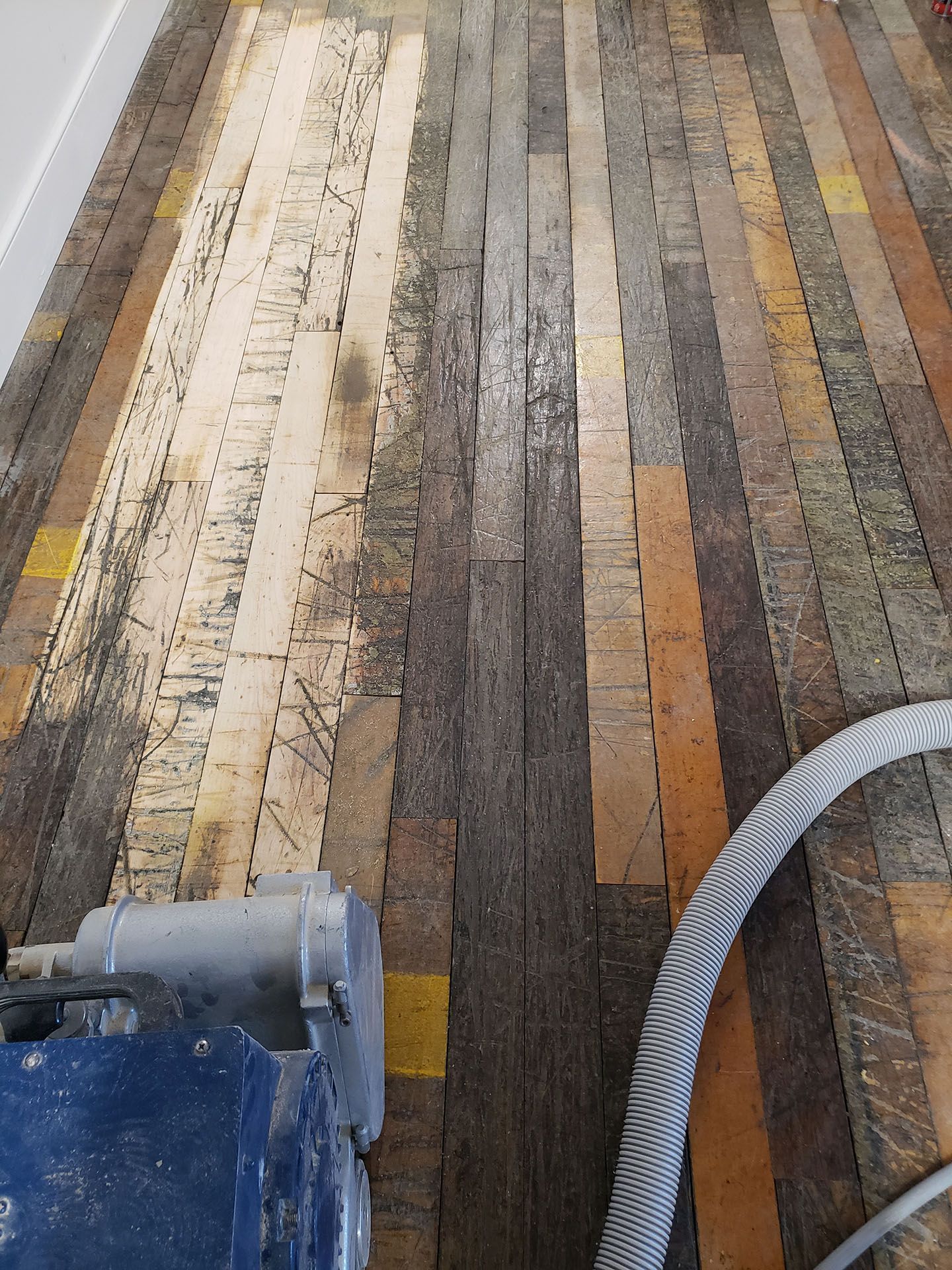 A vacuum cleaner is being used to clean a wooden floor