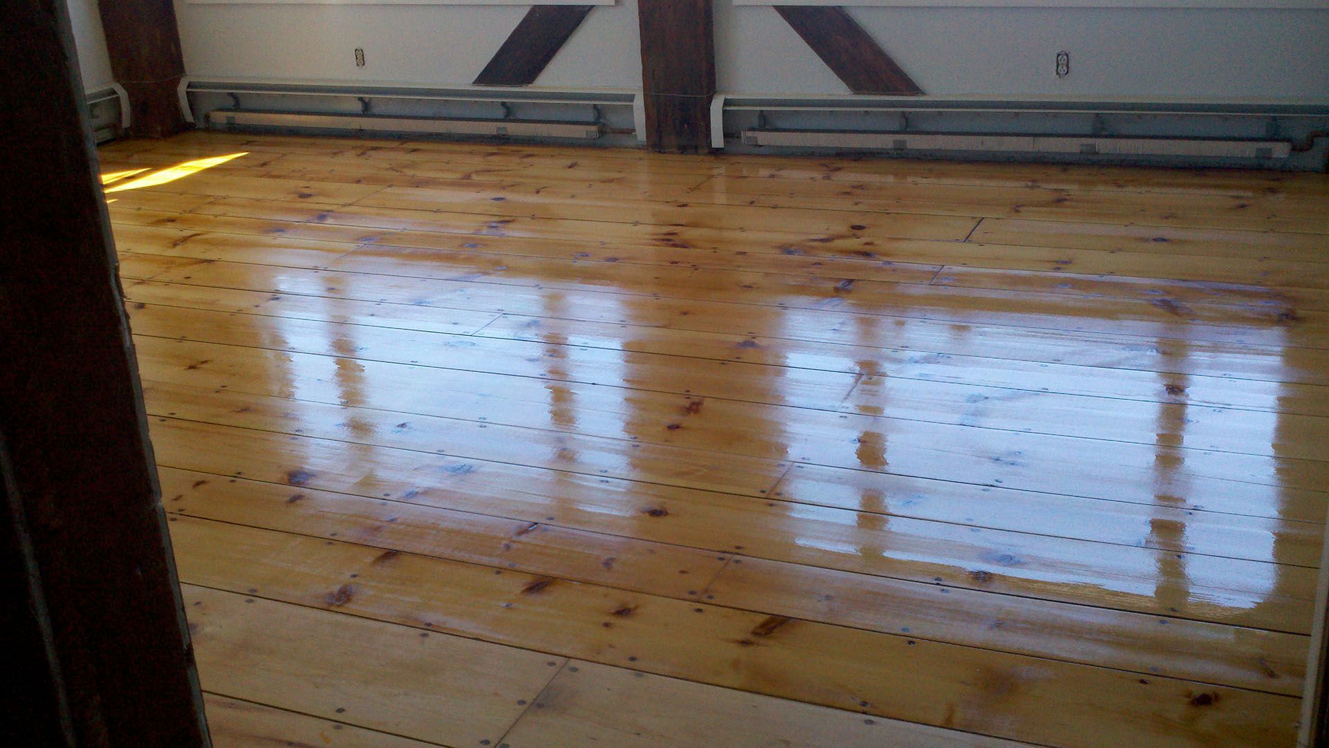 A room with a wooden floor and a lot of windows