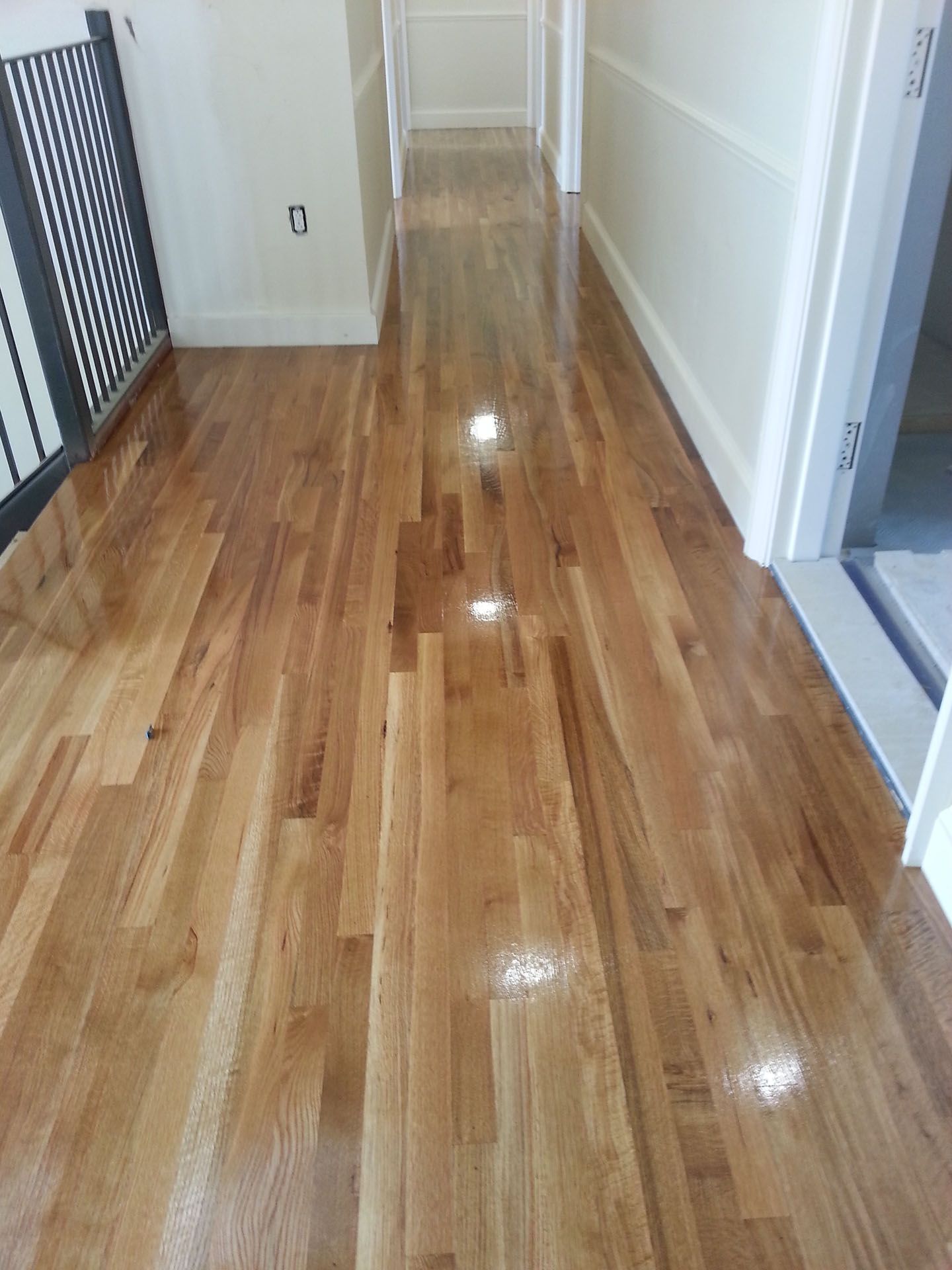 A hallway with hardwood floors and white walls