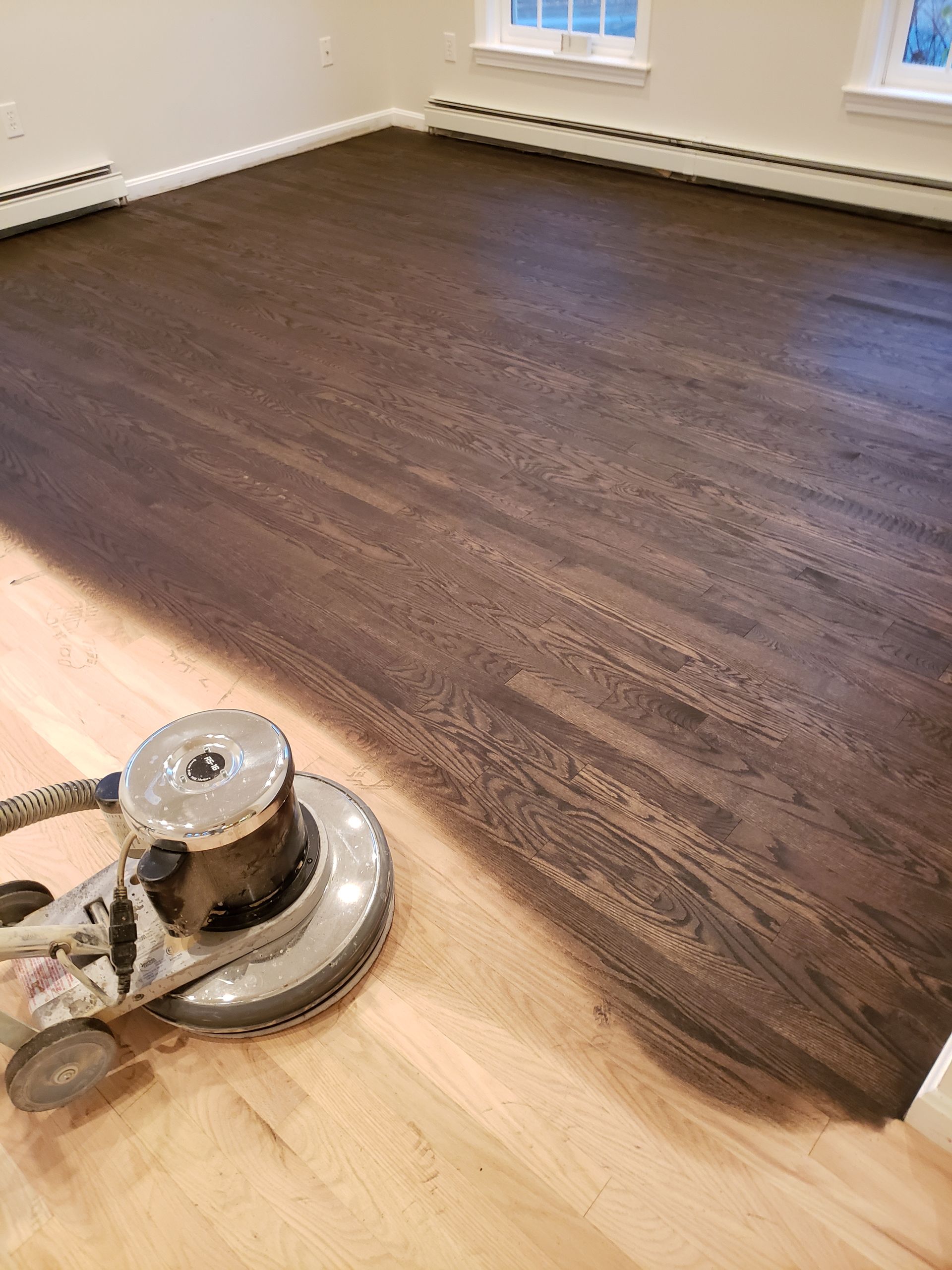 A machine is polishing a wooden floor in a room