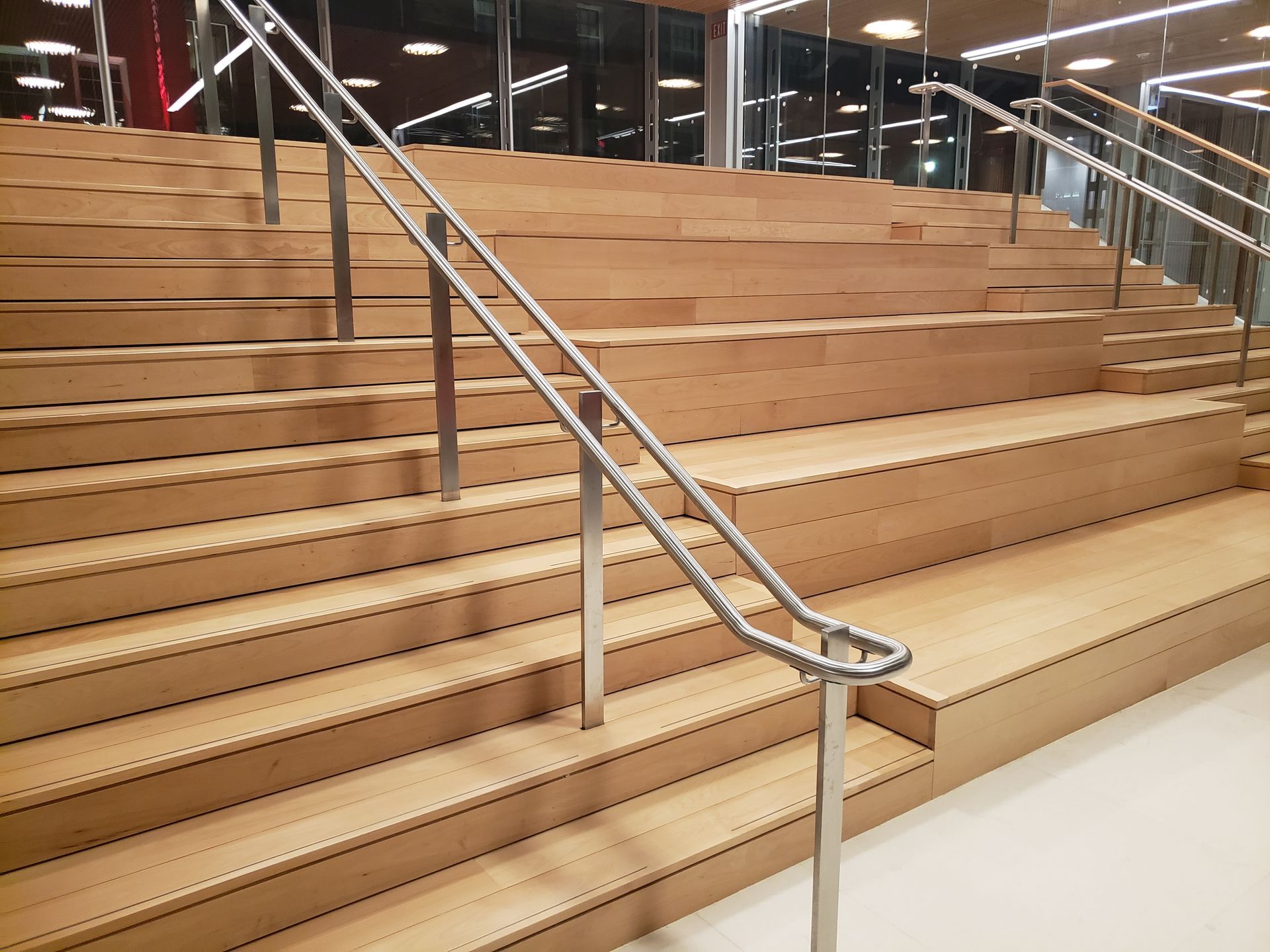 A set of wooden stairs with a metal railing