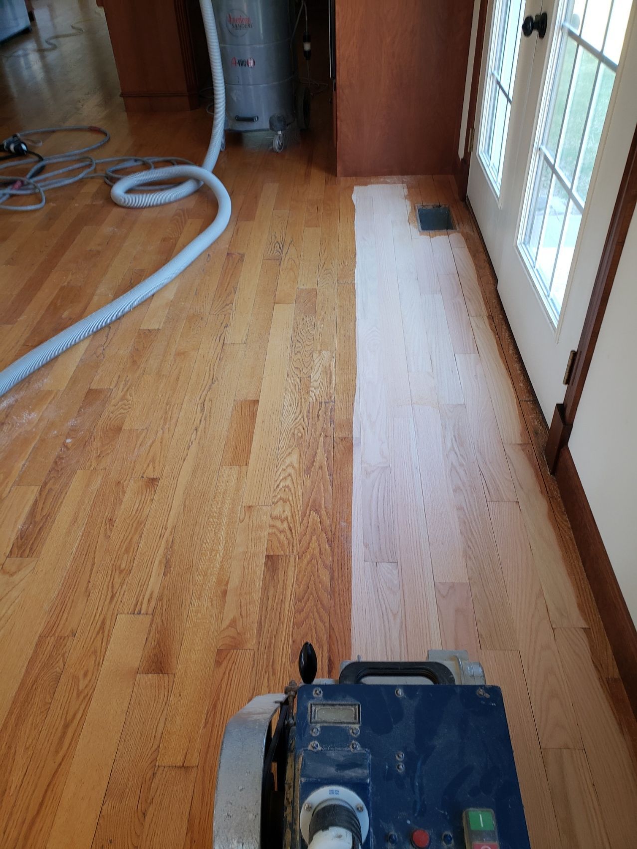 A machine is being used to sand a wooden floor