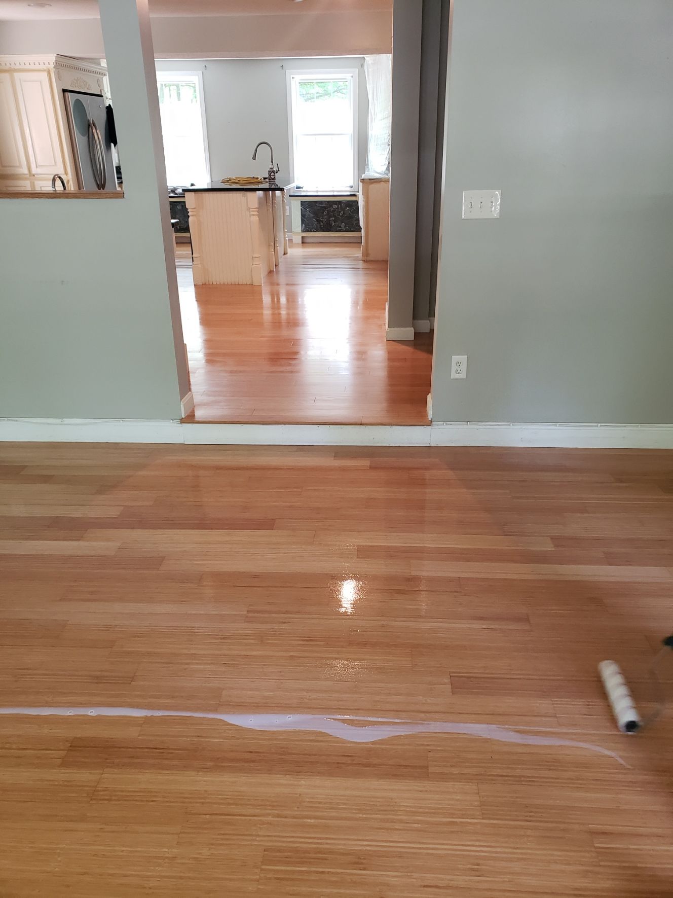 A wooden floor is being painted in a house