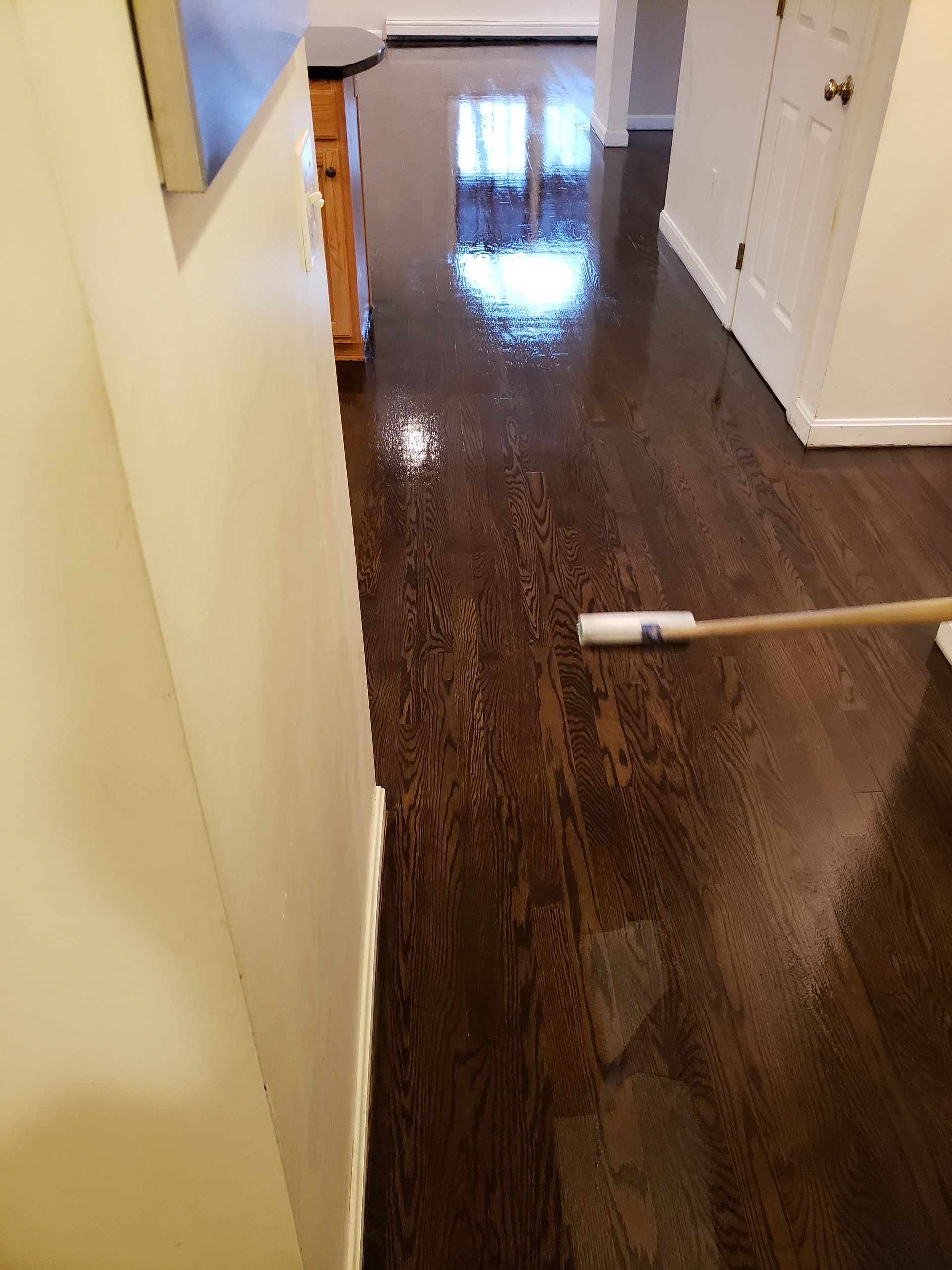 A person is cleaning a wooden floor with a mop