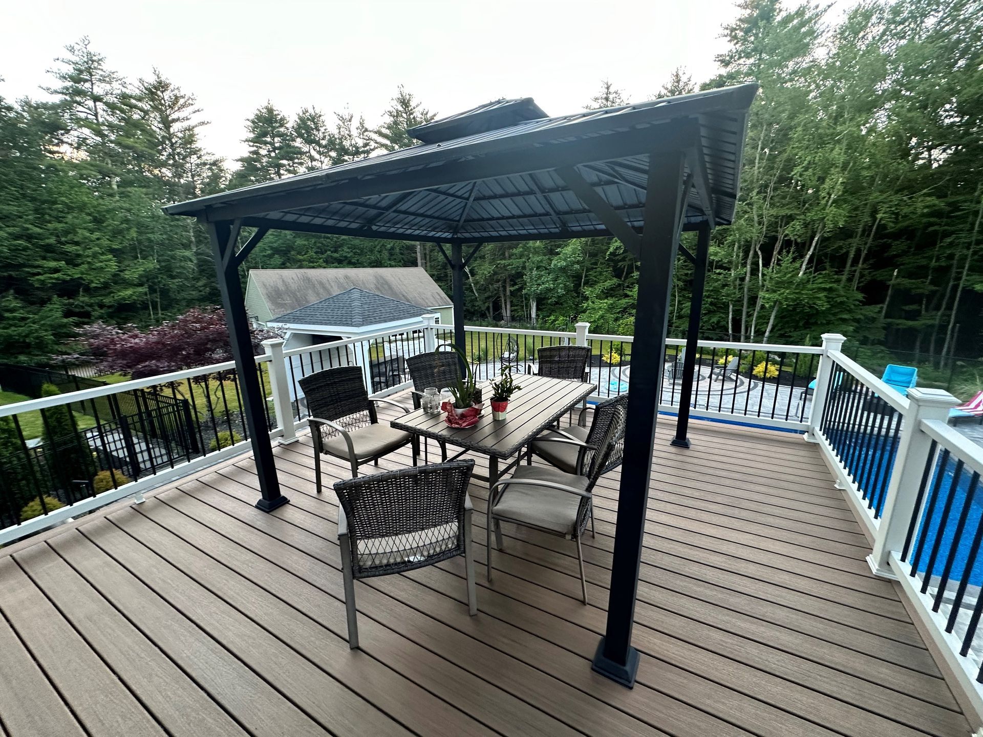 A deck with a gazebo and a table and chairs on it.