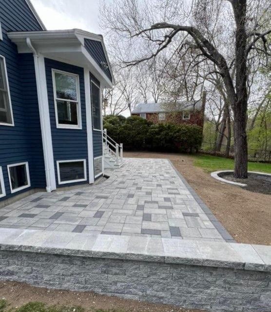 A blue house with a brick walkway leading to it