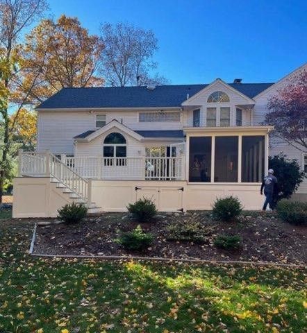 A white house with a screened in porch and stairs