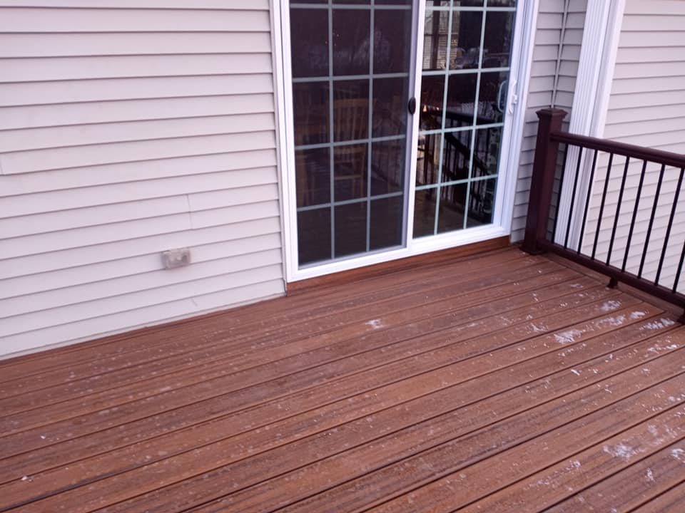 A wooden deck with a sliding glass door in the background