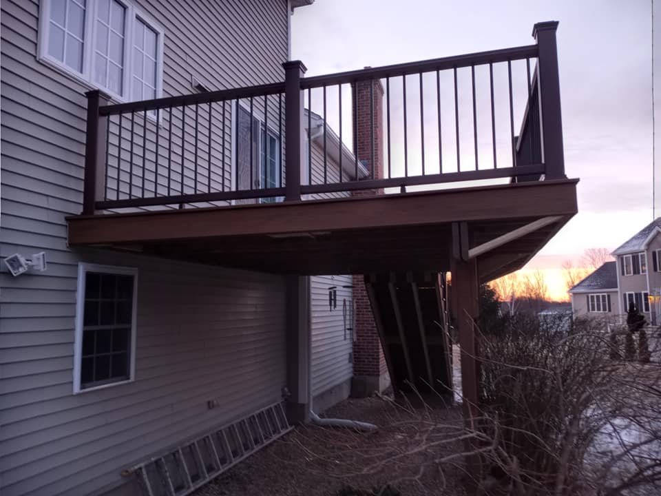 A house with a deck and a ladder in front of it
