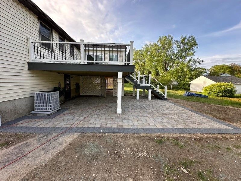 The back of a house with a large deck and stairs.