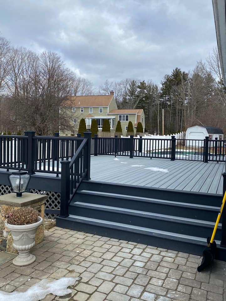 A large deck with stairs and a black railing