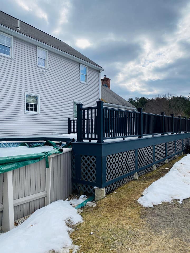 A house with a deck and a fence in front of it