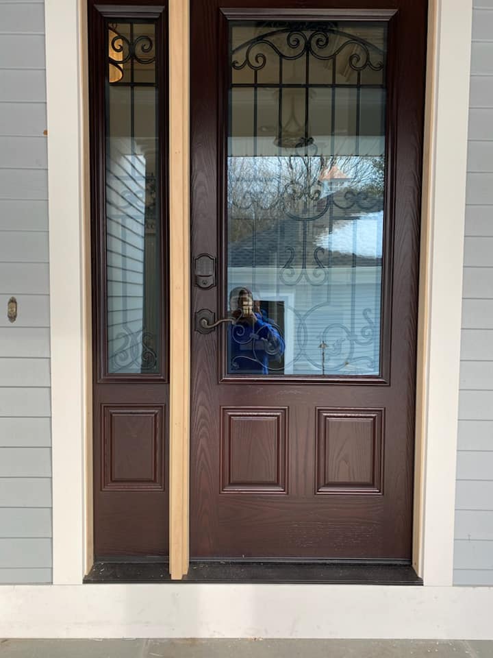 A person is taking a picture of their reflection in a door.