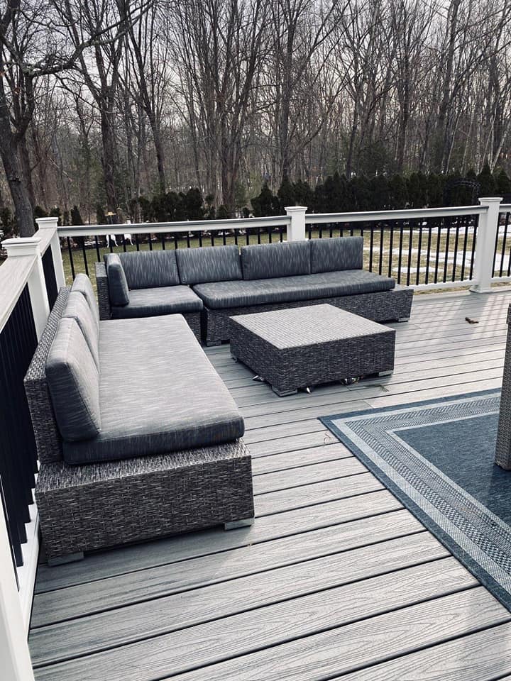 A deck with a couch and a table on it.