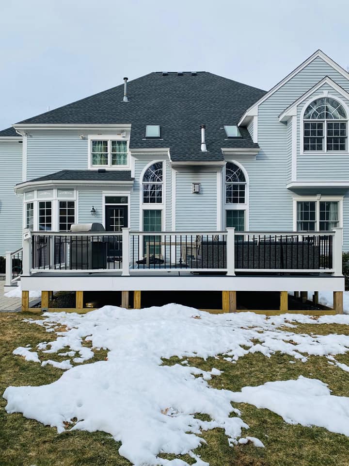 A large house with a large deck in the backyard