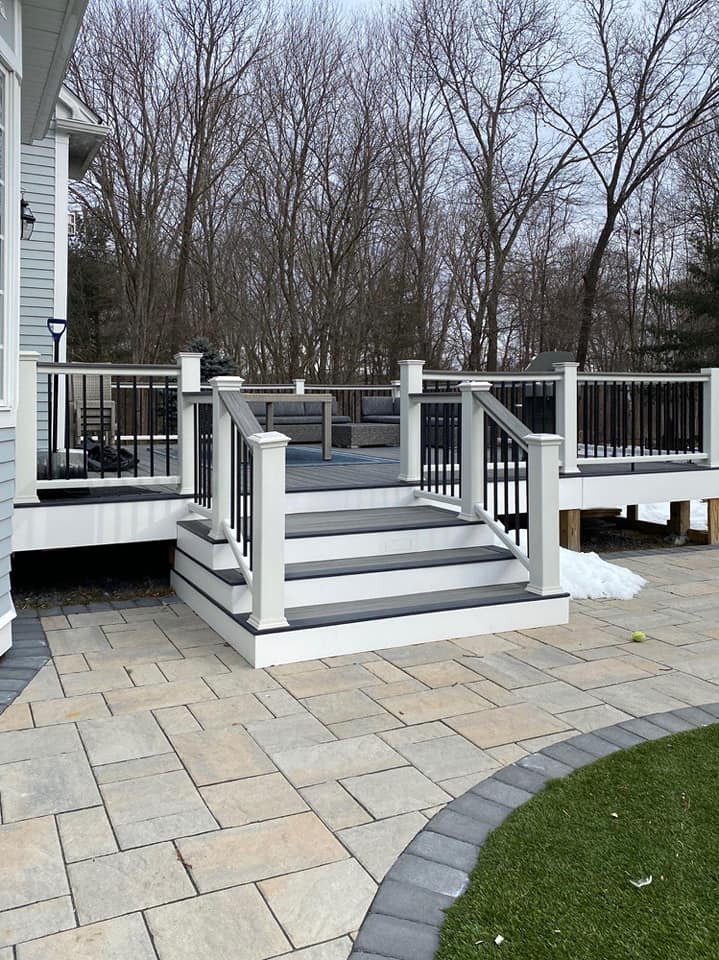 A deck with stairs leading up to it and trees in the background.