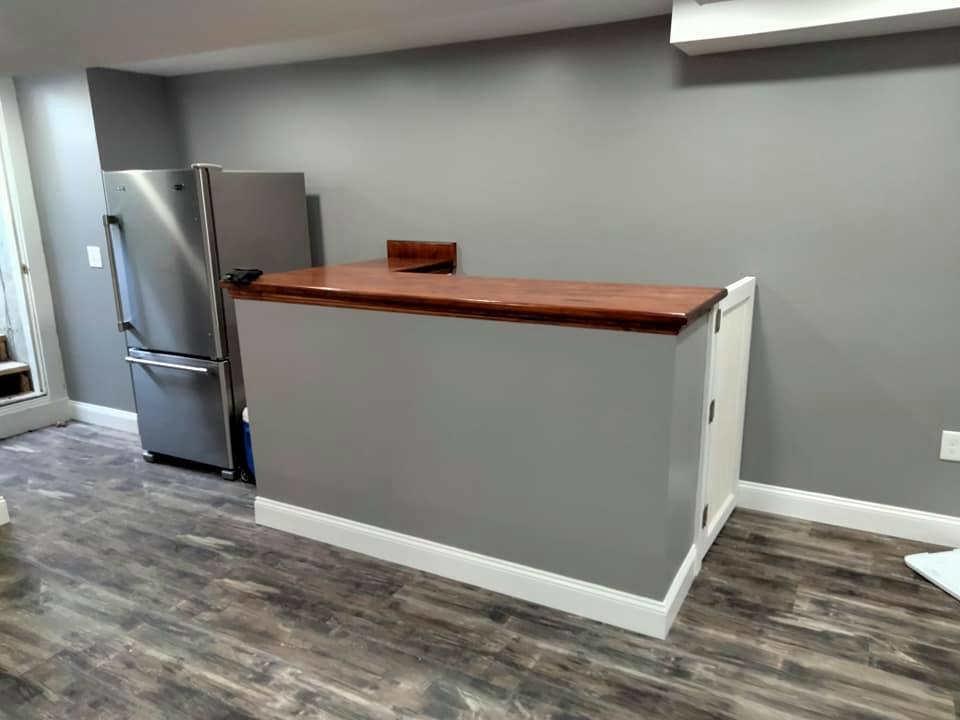 A kitchen with a stainless steel refrigerator and a wooden counter.