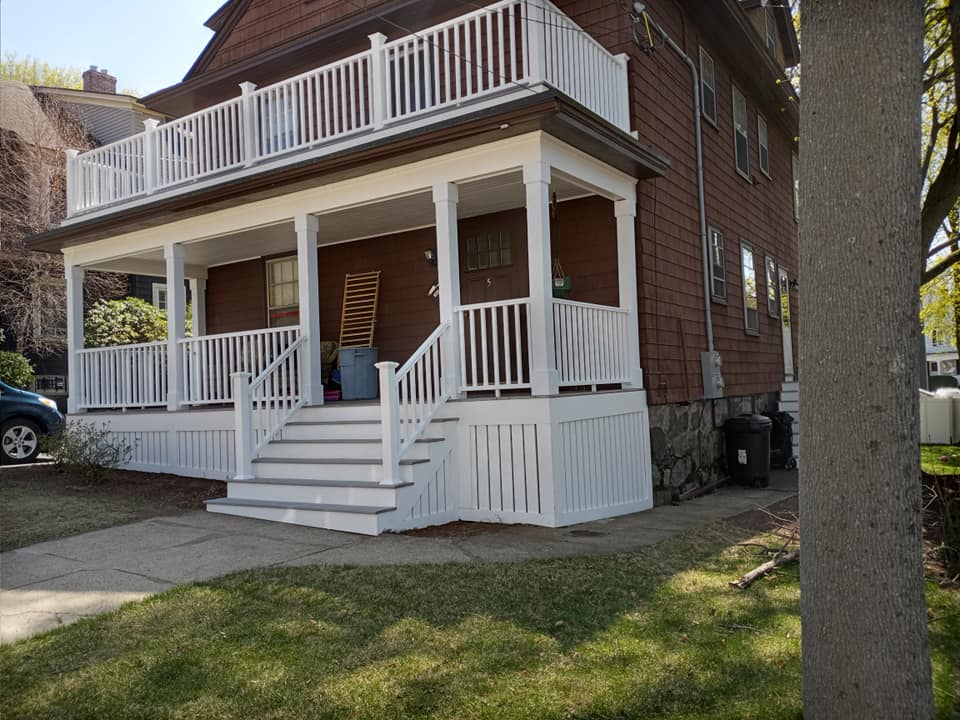 A brown house with a white porch and stairs