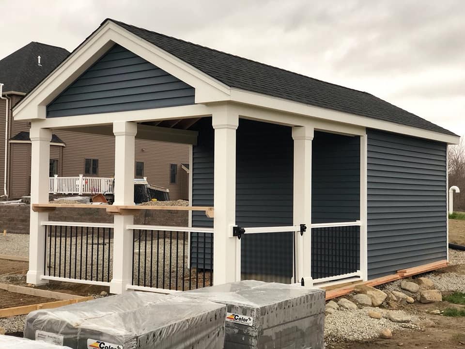 A gazebo with a screened in porch is being built in the backyard of a house.