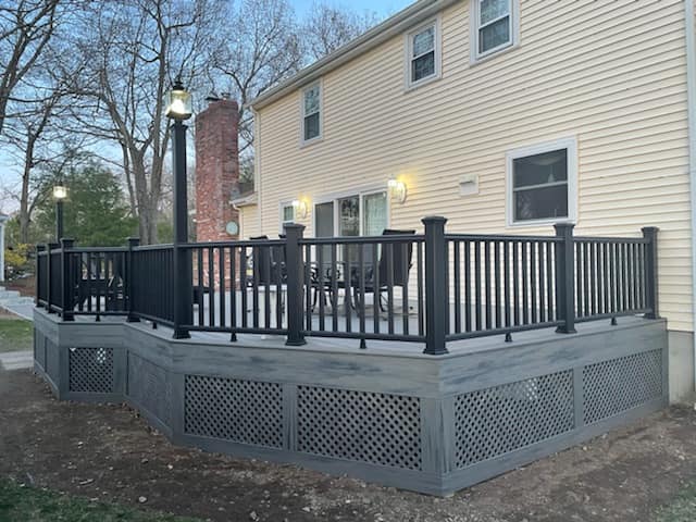 A deck with a black railing in front of a house