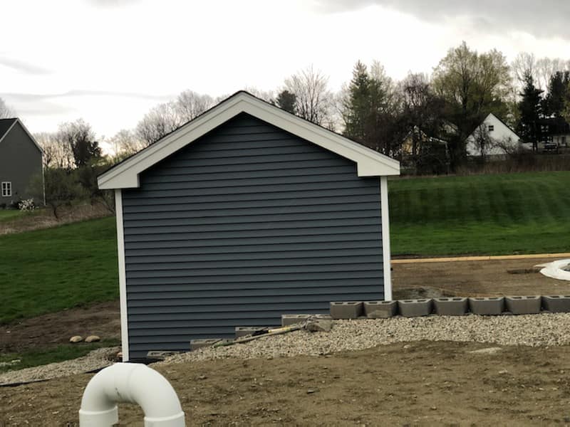 A shed with a pipe attached to it in front of it