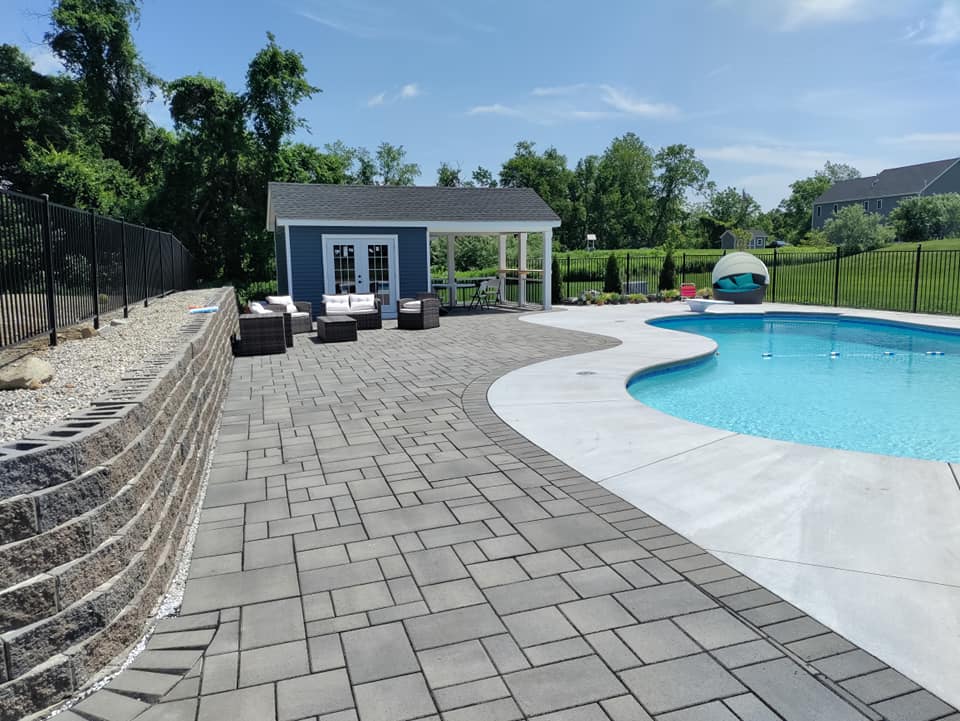 A large swimming pool with a blue house in the background